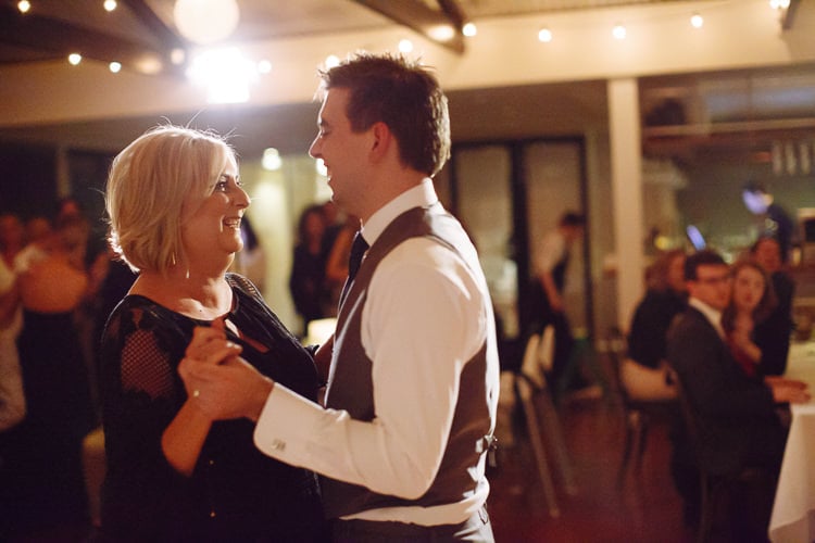 Luke dances with a smiling woman in black beneath festoon lights at Sunnybrae Estate.
