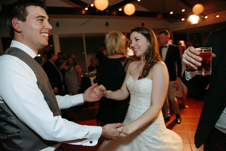 Shannon and Luke dance together among guests beneath paper lanterns at Sunnybrae.
