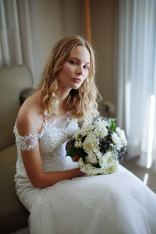 Off-shoulder lace and loose waves in the curtained corner