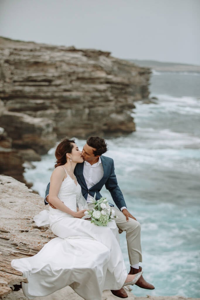 Jeannette and Pierre kiss while seated above the surf at Cape Banks, La Perouse.