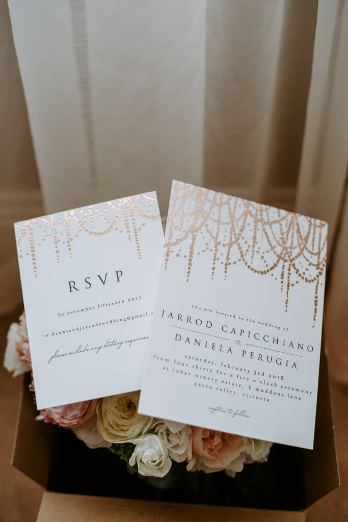 Rose-gold chandelier invitations announce Jarrod and Daniela at Tokar Estate
