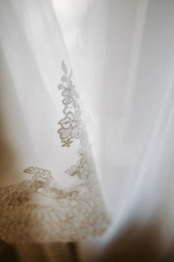Applique flowers trail down the sheer fall of the veil