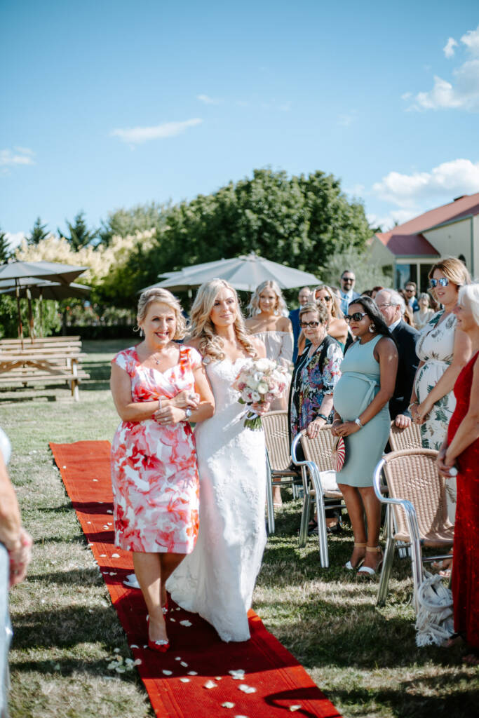 Danni walks towards Jarrod beside a woman in coral florals.