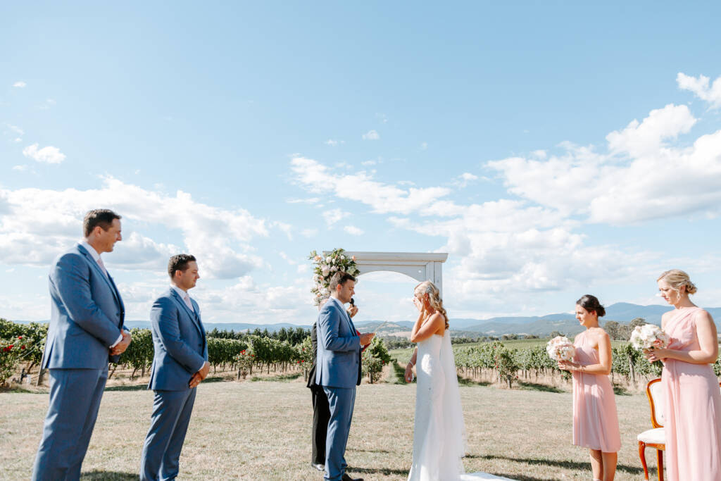 Jarrod speaks his vows to Danni as she wipes an eye.