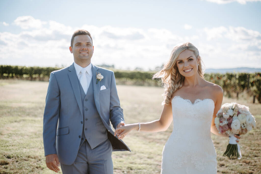 Danni and Jarrod walk hand in hand as the breeze lifts her curls.