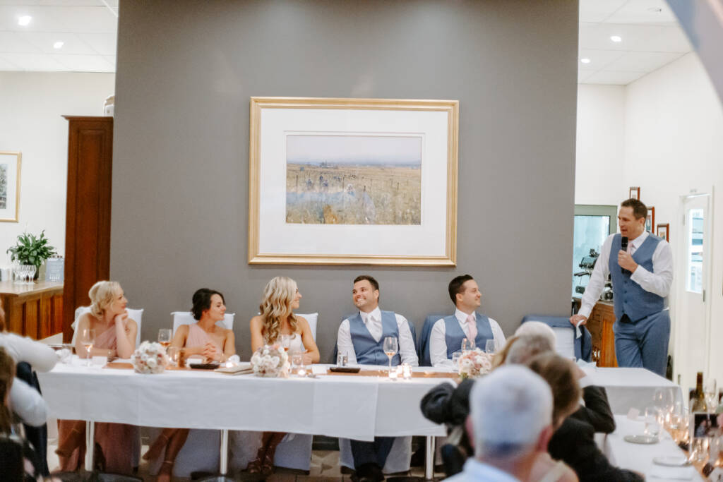 A groomsman speaks beside Tokar Estate's bridal table as the wedding party listens.