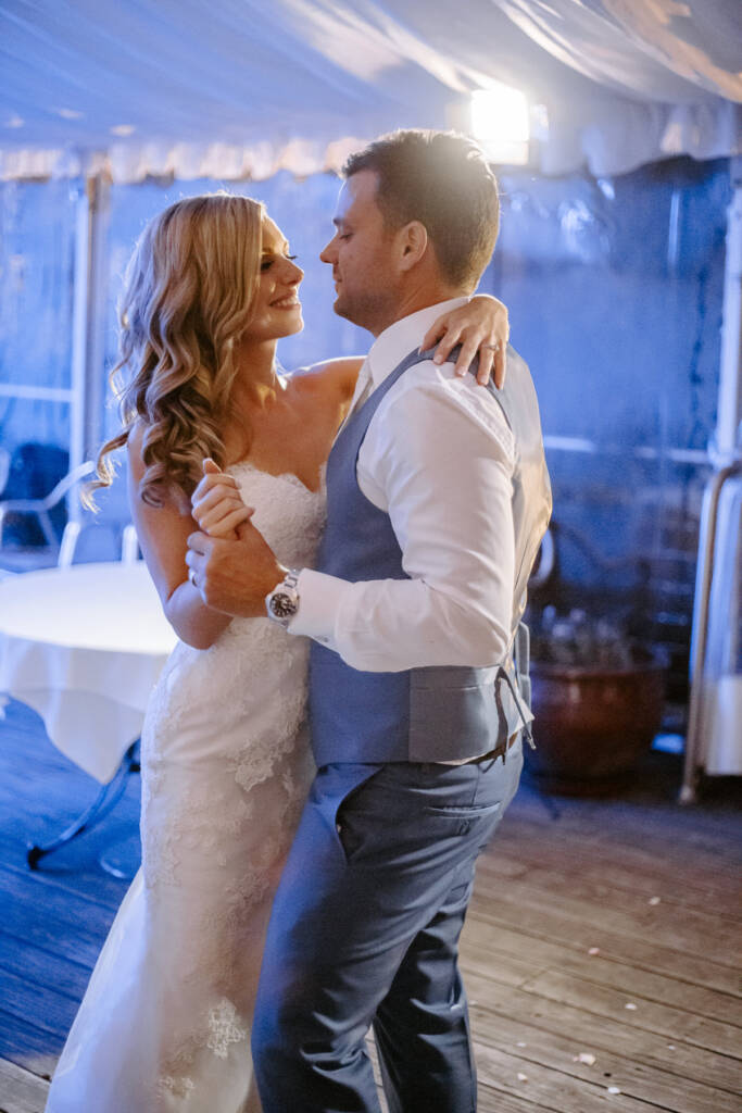 Danni and Jarrod begin their first dance beneath Tokar Estate Winery's marquee lights.