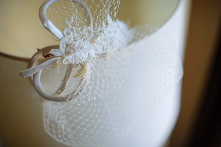 A lace-and-pearl birdcage veil rests on the lampshade