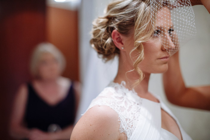 Lindsey draws the birdcage net down over her eye, blonde curls pinned high.
