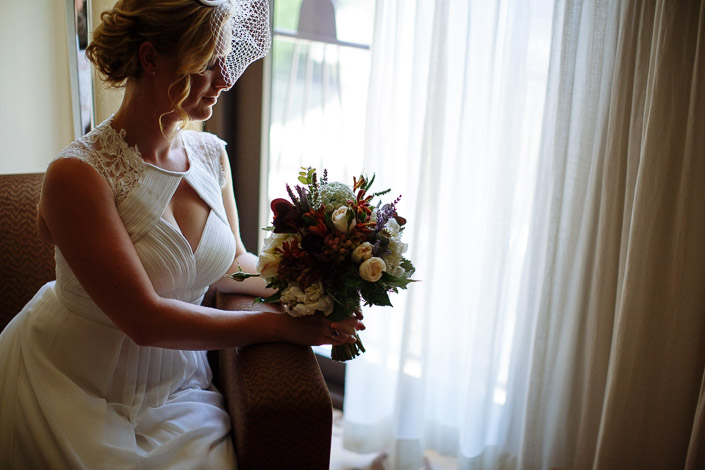 By the sheer curtains Lindsey settles the autumn toned bouquet on the armrest.