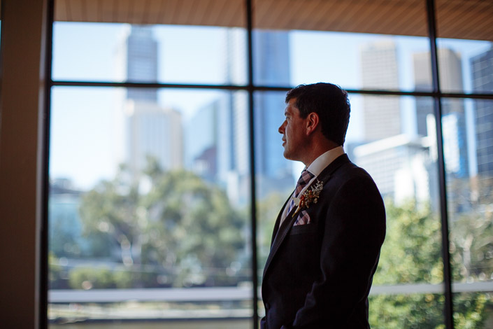 Dennis's profile against the skyline, sprigs of wattle on the lapel.