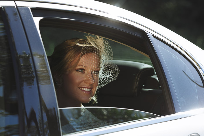 Through the car window, Lindsey's smile glows behind the birdcage netting.