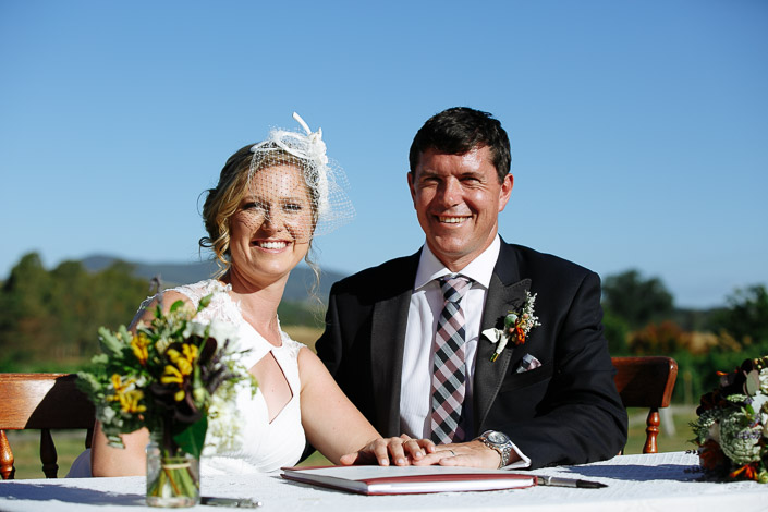 Two beaming faces over the red-bound register on the lace cloth