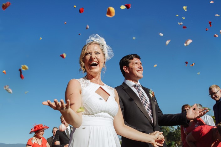 Petals hang in the blue as Lindsey laughs behind the birdcage net.
