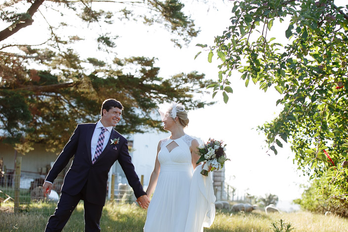 Dennis reaches back for Lindsey's hand under the apple boughs.