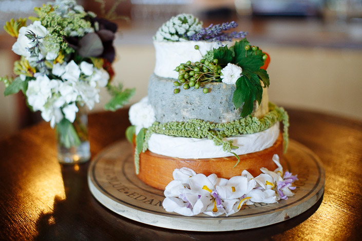A cheese-wheel tower crowned with lavender and hop leaves
