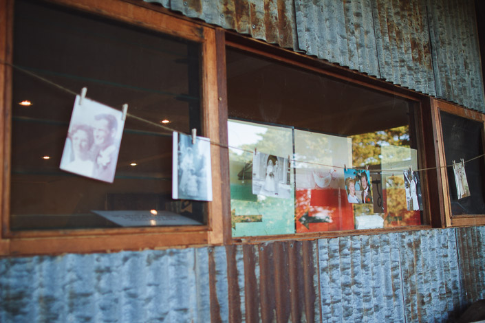 Old wedding photographs peg along a string against the corrugated iron wall.