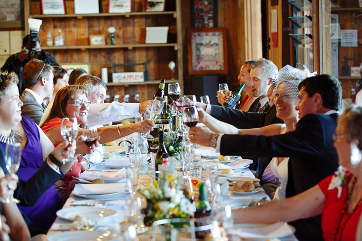 Glasses stretch across the long table for a full-reach toast