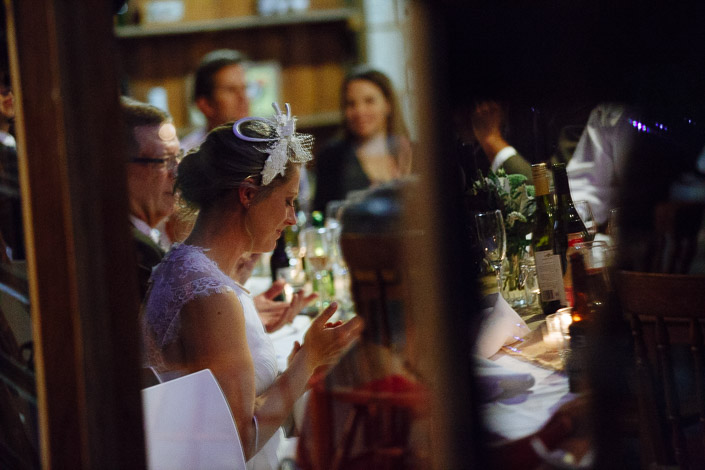 Applause from Lindsey at the table as another speech wraps, veil pinned up.