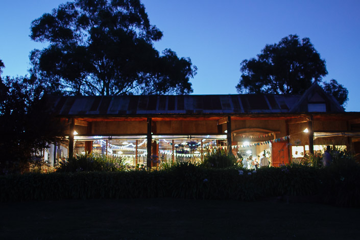 The old hay shed glows against the last of the twilight, bunting inside.
