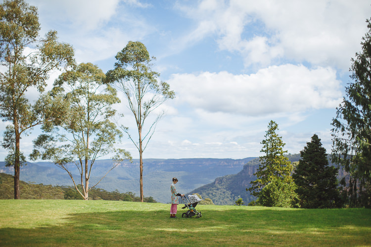A woman stands beside a pram on the lawn at Yester Grange overlooking the valley