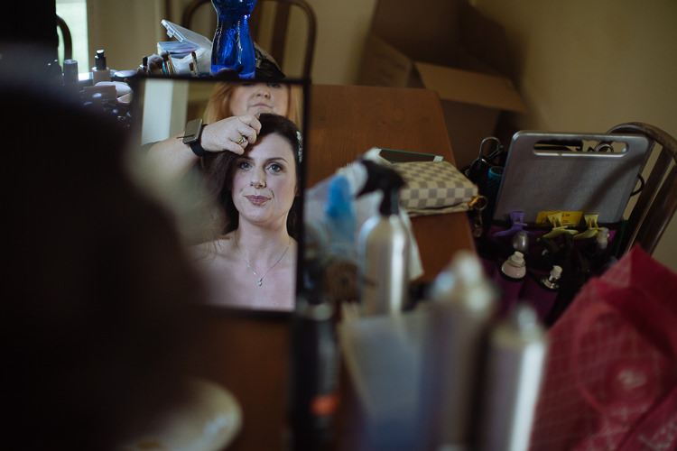 Heidi watches a tabletop mirror during bridal hair preparation at Yester Grange Estate