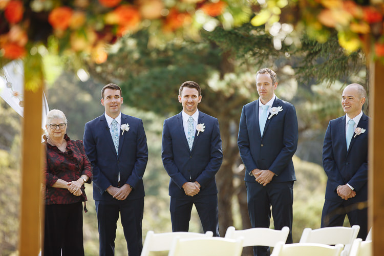 Russell and three groomsmen wait with the celebrant before the garden wedding at Yester Grange Estate