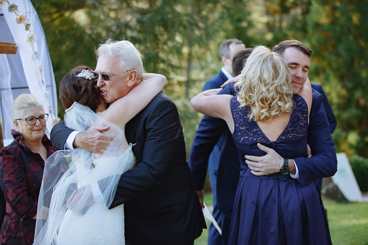Heidi hugs an older man as Russell embraces a woman in a navy dress