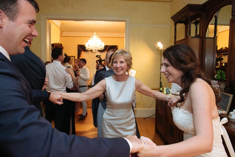 Heidi and Russell join hands with an older woman while dancing at Yester Grange