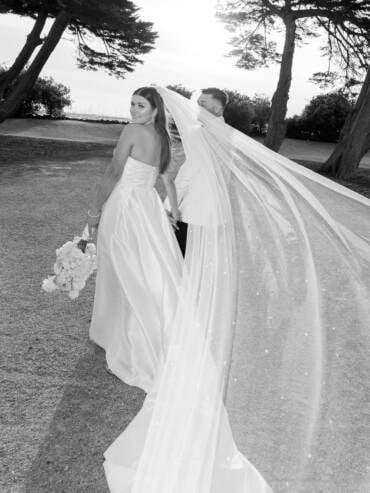 The pearl veil streaming as they walk the St Kilda foreshore — Harbour Room RMYS wedding