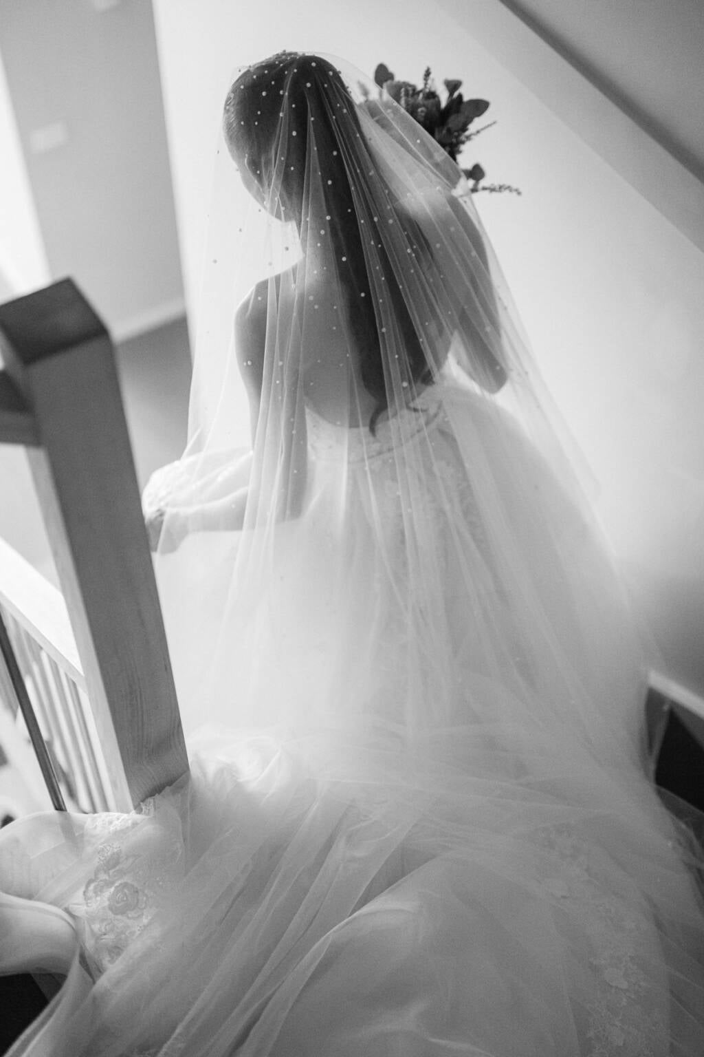 The bride's pearl-studded veil cascading behind her on the staircase at Meadowbank Estate, Melbourne