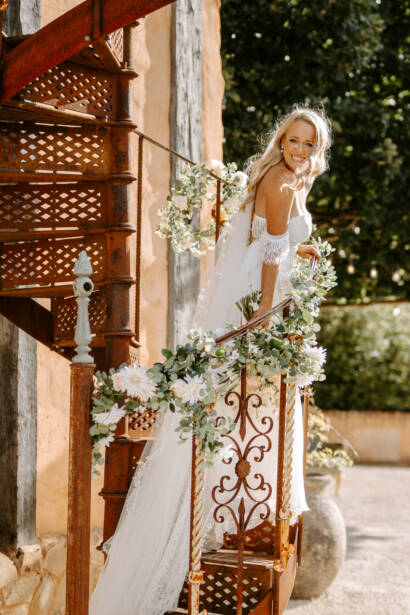 The bride on the garland-wrapped spiral staircase at Mont Du Soleil