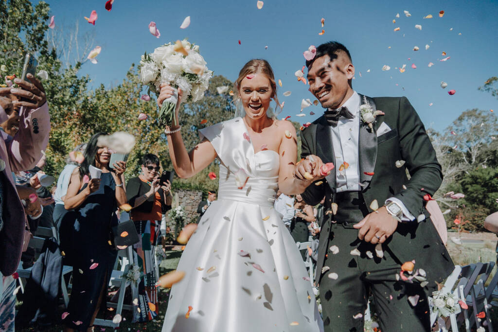Rose petals rain over Georgie and Johnny's aisle exit in the Mercure Ballarat gardens