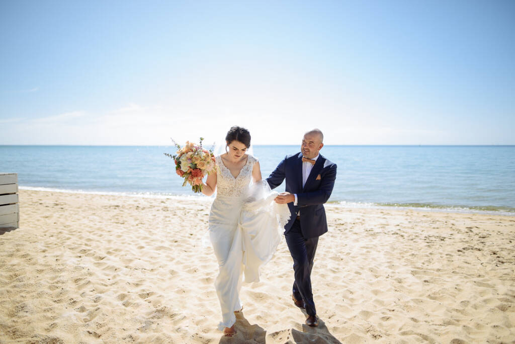 Brad steadies the train as Caitlin crosses the Peninsula sand before their Stillwater at Crittenden reception
