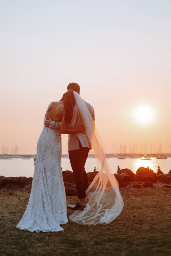 An embrace at sunset by the water, veil trailing &mdash; Prince Deck, St Kilda