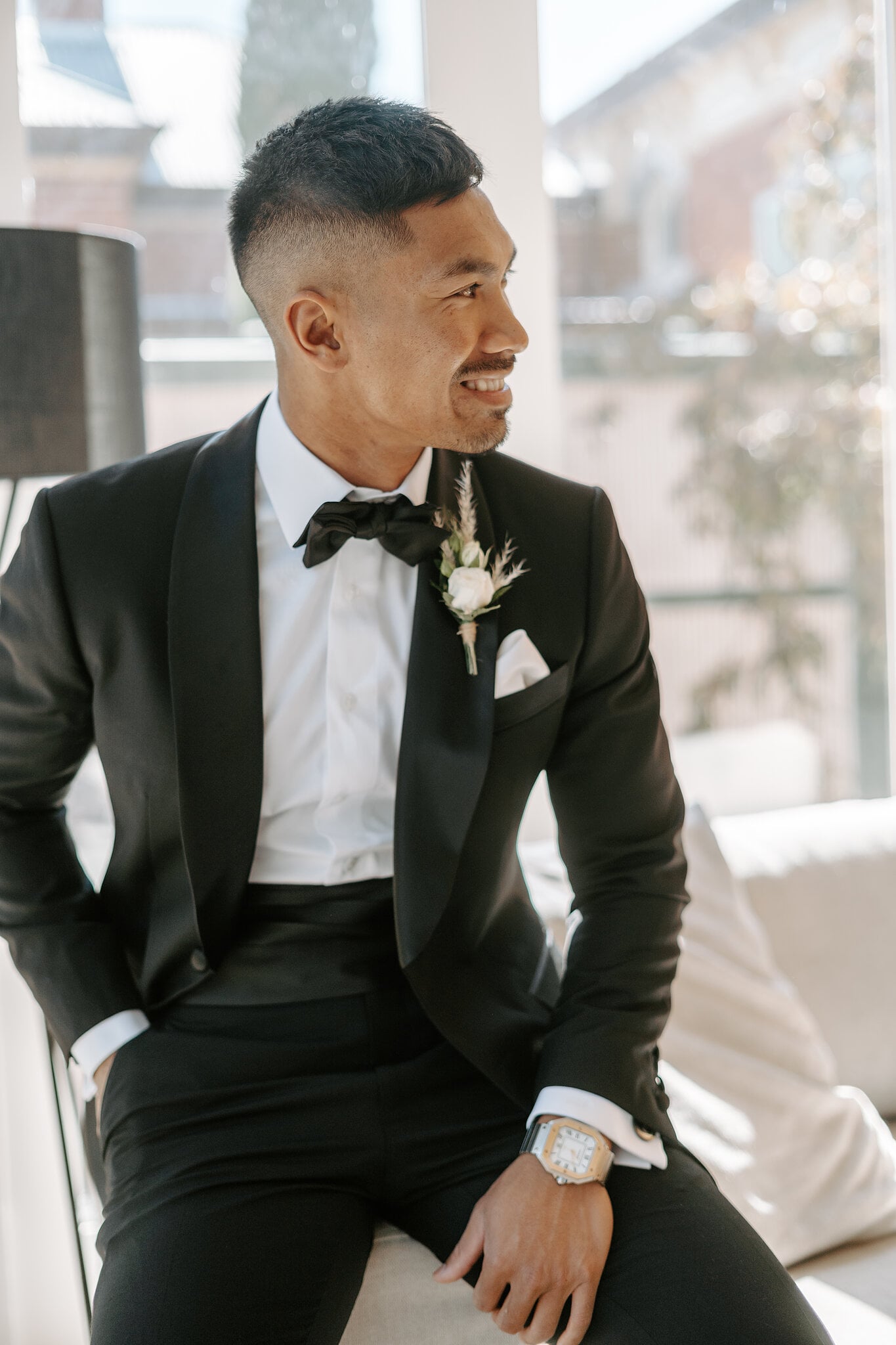 Johnny waits by the window in his black tuxedo and white boutonniere before the Ballarat ceremony.