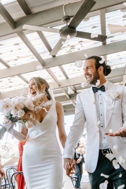 A petal toss as they walk out under the pergola at Barn & Co, Balnarring
