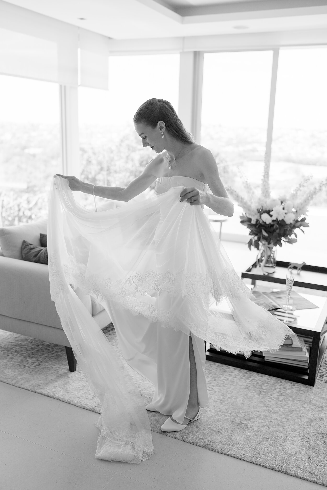 Michele lifts her lace-edged veil in the living room as she gets ready in Bellevue Hill.