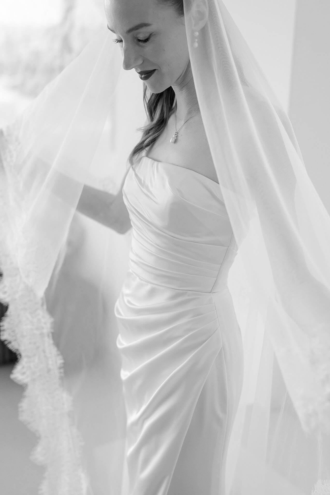 Soft window light across Michele’s veil and draped satin bodice.