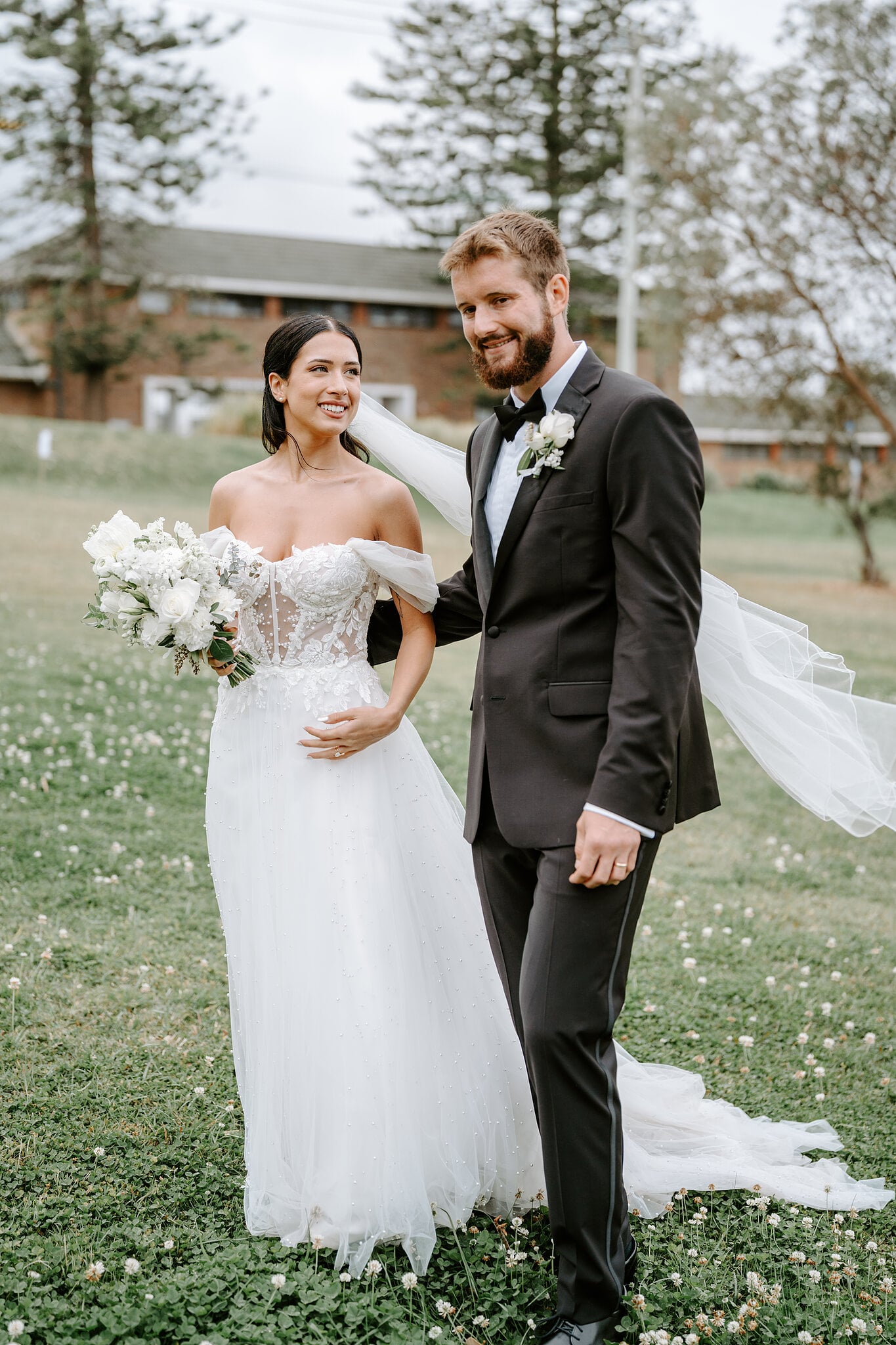 Chris grins at the camera as Alexa’s veil lifts in the breeze on the lawn at Middle Head.