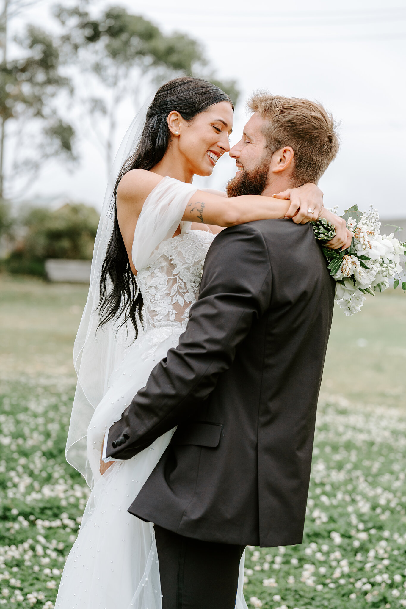 Nose to nose, Alexa wraps her arms around Chris on the Middle Head lawn.