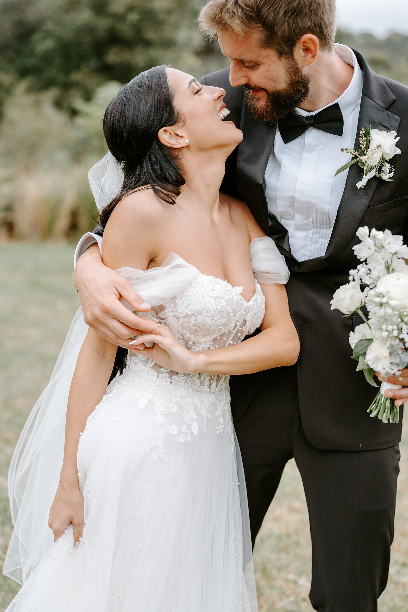 Alexa bursts out laughing as Chris wraps her in a hug, bouquet in his hand.