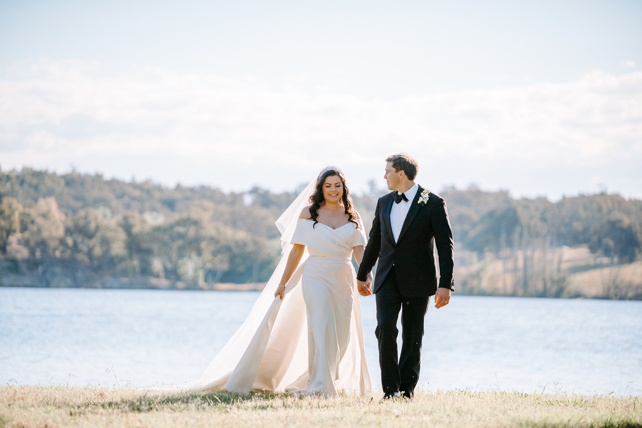 Helena and Xavier walk hand in hand beside Lake Burley Griffin in Canberra.