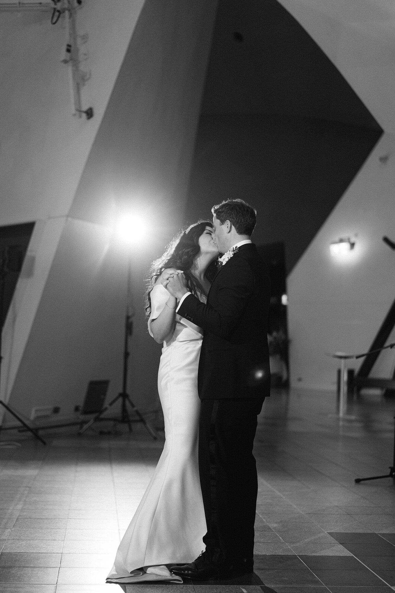 Black-and-white portrait of Helena and Xavier kissing on the National Museum of Australia dance floor.