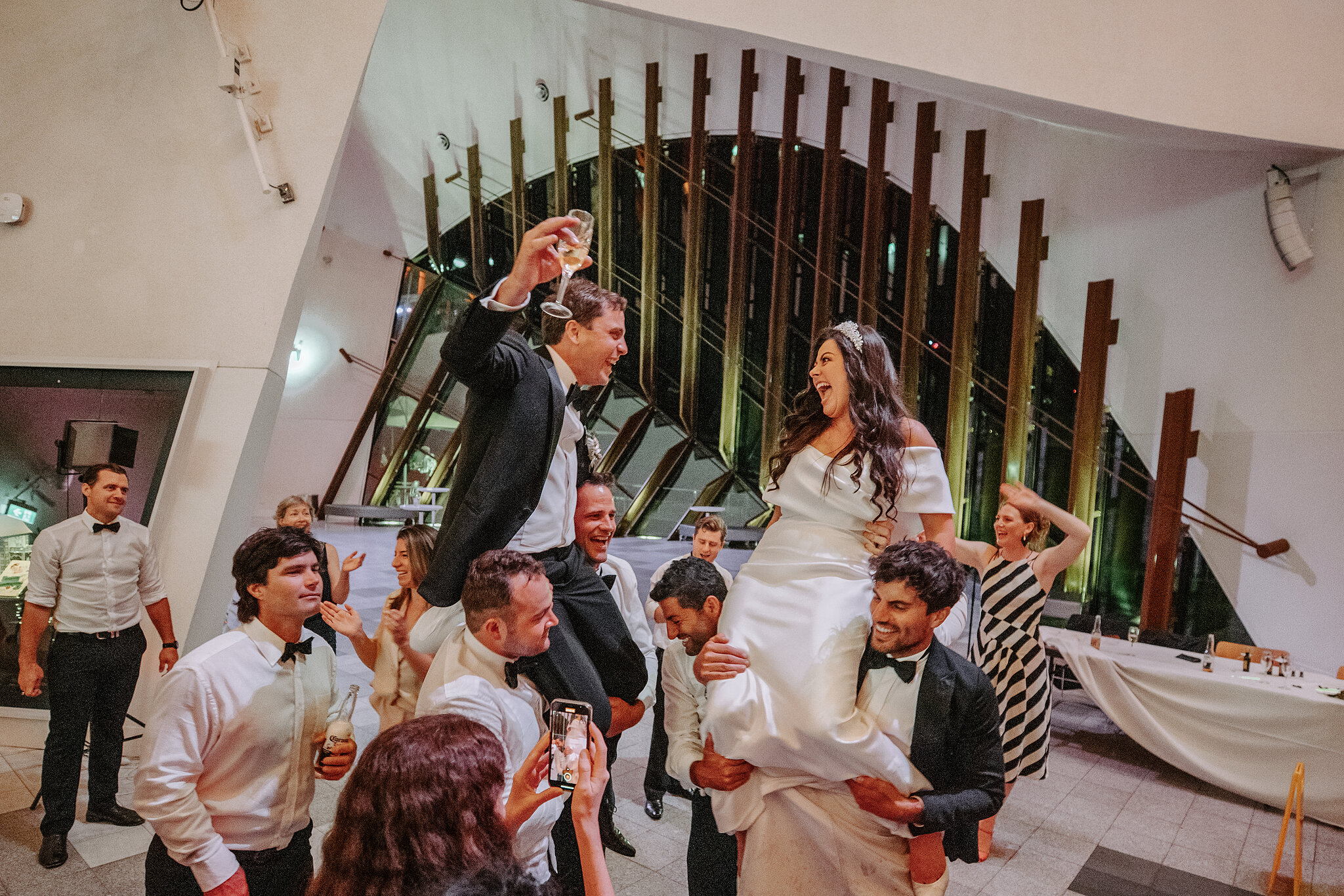 Wedding guests lift Helena and Xavier on the dance floor at the National Museum in Canberra.