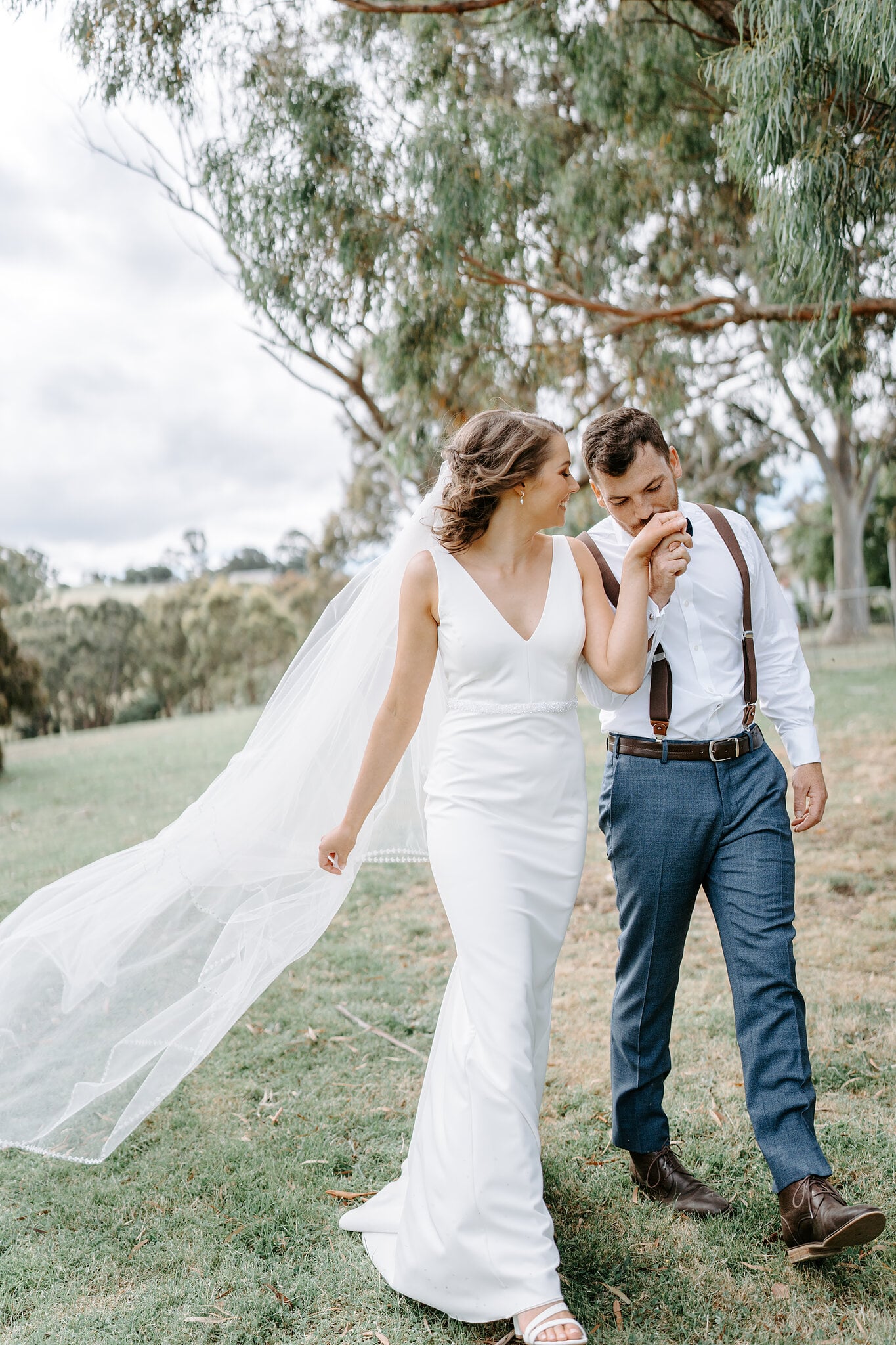 He kisses her hand as they walk the lawn under the gums at Inglewood Estate, Yarra Valley