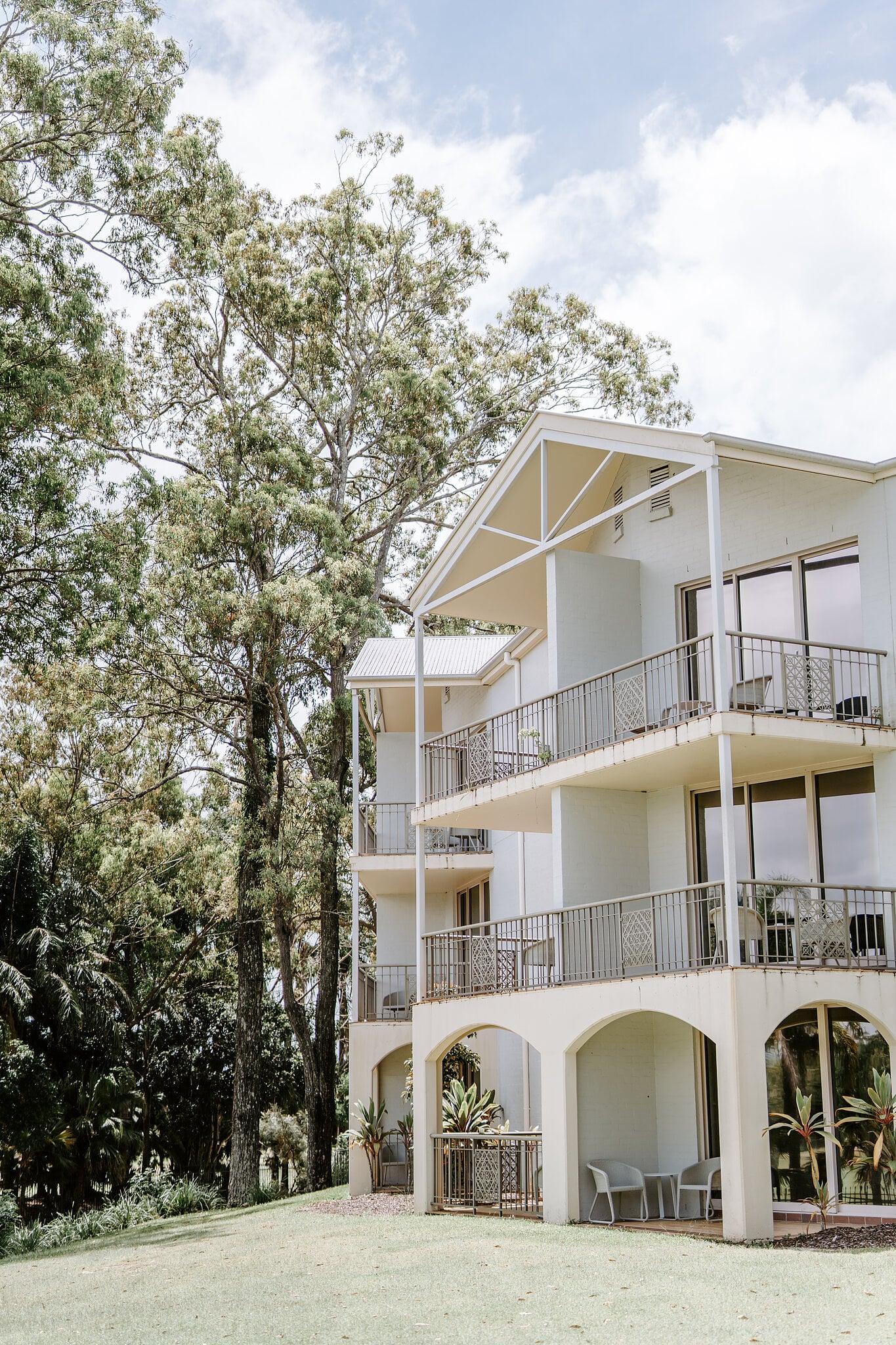 A Queenslander-style accommodation wing of InterContinental Sanctuary Cove Resort among tall gums on the wedding morning.