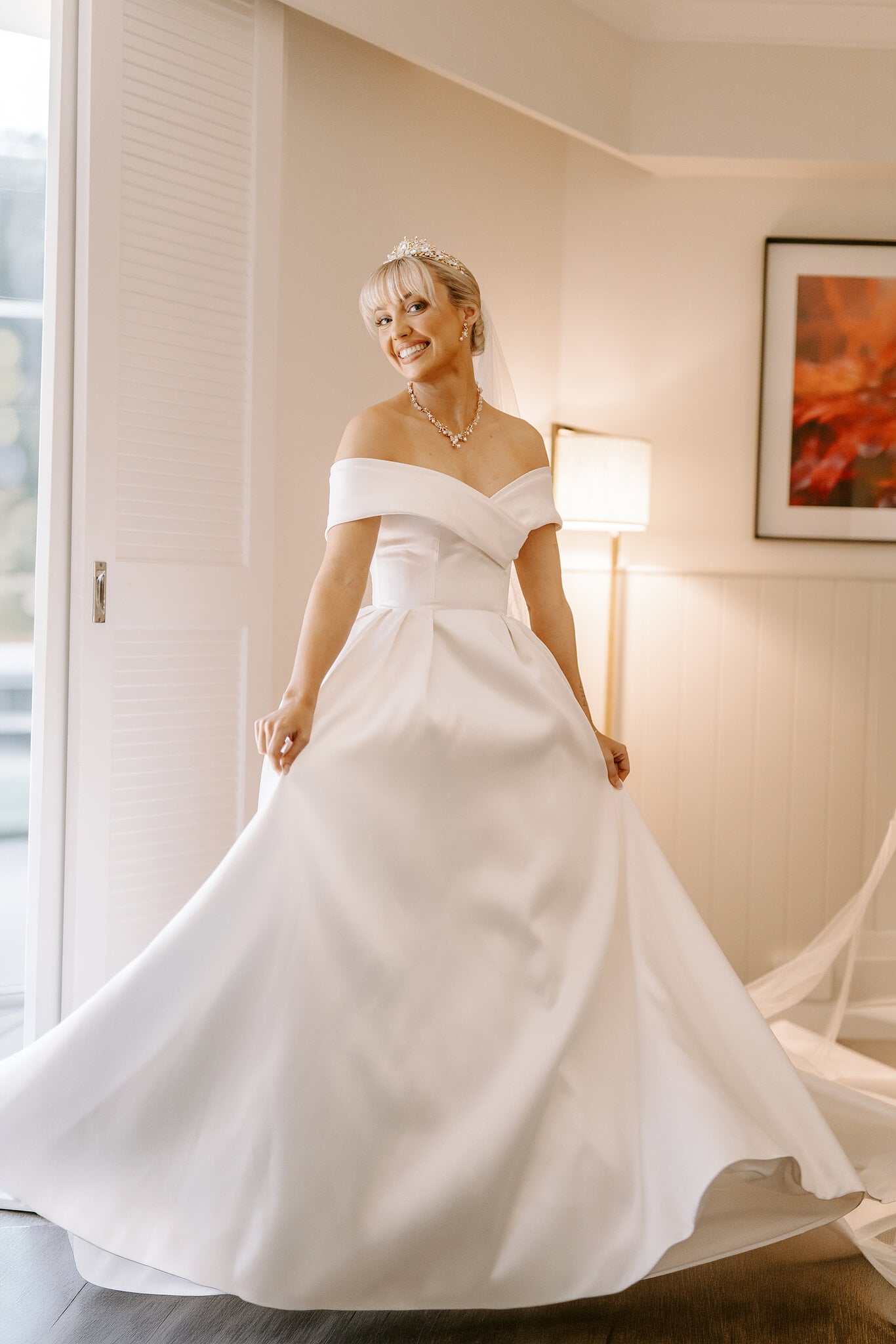 Ashley twirls her full satin skirt, laughing, just before leaving for the chapel.