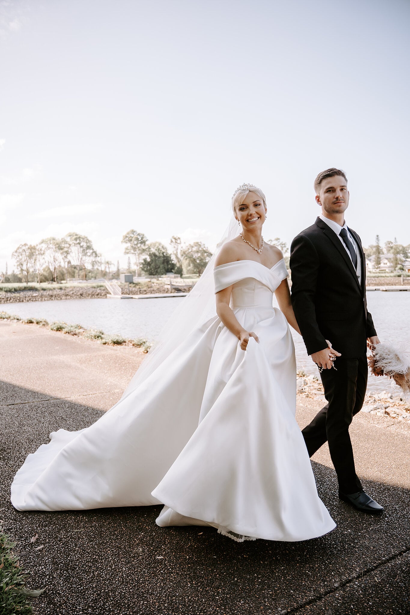 Ashley and Lane stroll hand in hand along the waterfront path at InterContinental Sanctuary Cove.