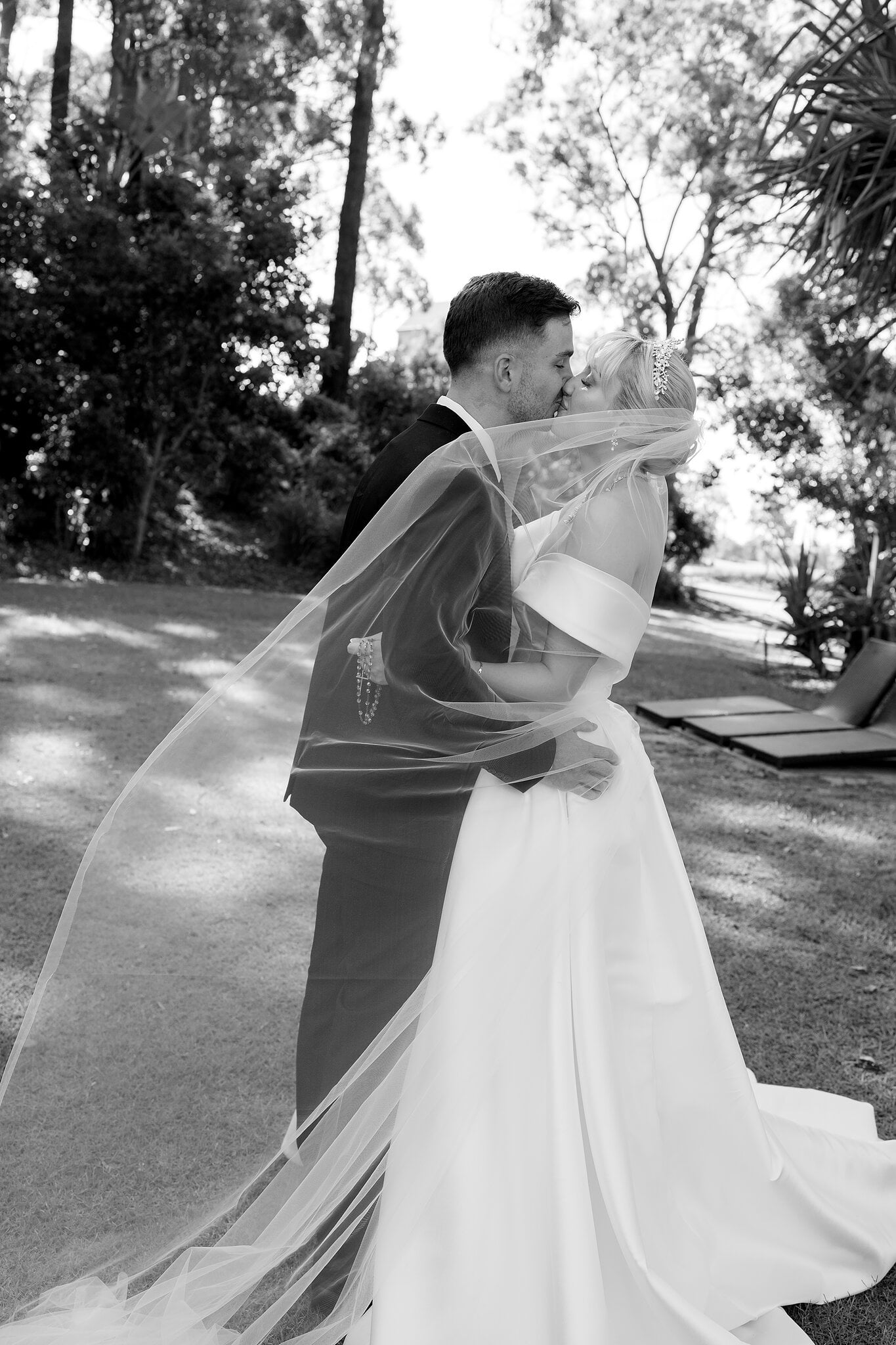 Ashley’s veil swirls around her and Lane as they embrace in the gardens.